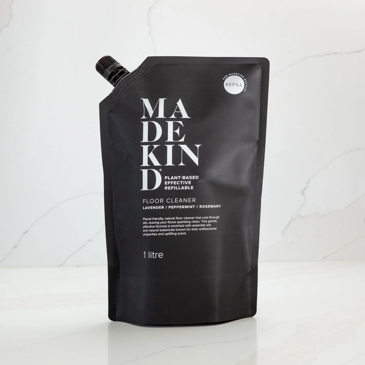 refillable container for natural floor cleaner with 'Made Kind' branding on a white background